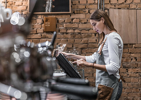 Frau arbeitet selbstständig in Café
