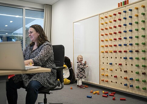New Work: Mama mit Kind im Eltern-Kind-Zimmer in der Firma