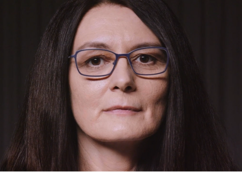 Portraitbild von Sehada Seitz, eine Frau mit dunklen langen Haaren und Brille
