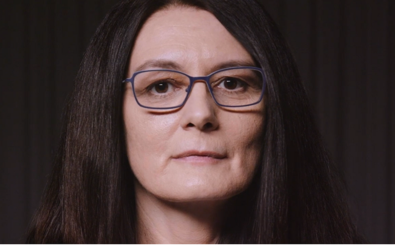 Portraitbild von Sehada Seitz, eine Frau mit dunklen langen Haaren und Brille