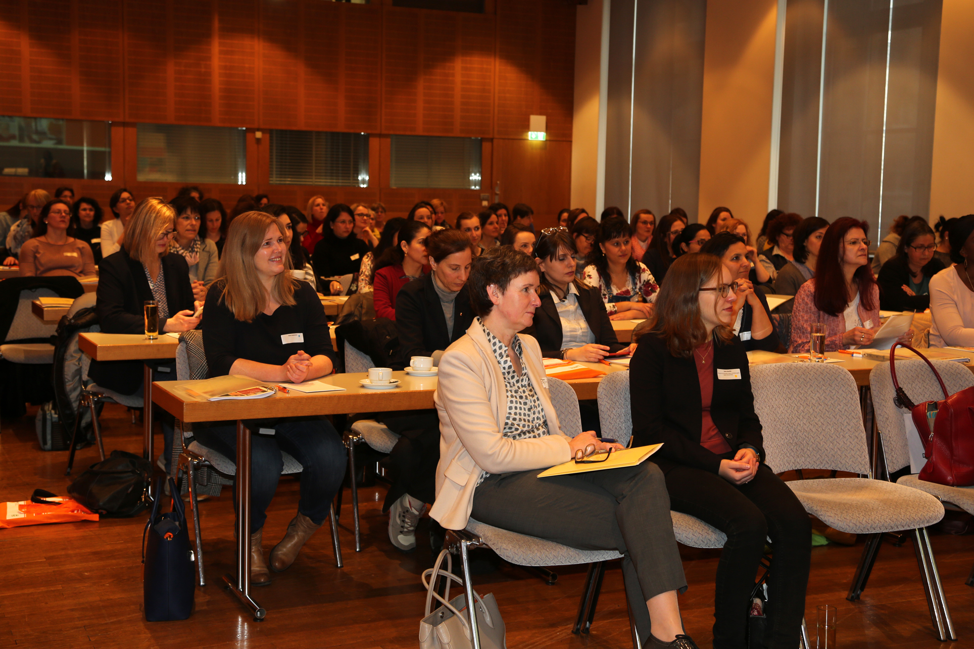 Die Teilnehmenden der Auftaktveranstaltung des Mentorinnen-Programms sitzen in einem großen Saal und folgen einem Vortrag. 